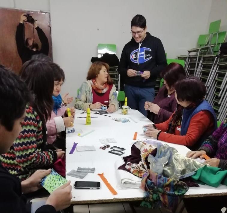 Alumnos de Taller de Facilitación de Procesos Participativos enseñando a hacer billeteras con tetra pack